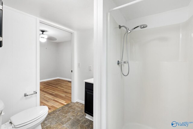 bathroom featuring hardwood / wood-style floors, vanity, a shower, ceiling fan, and toilet