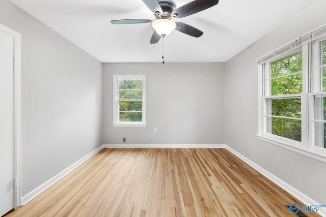 empty room with ceiling fan and light hardwood / wood-style flooring