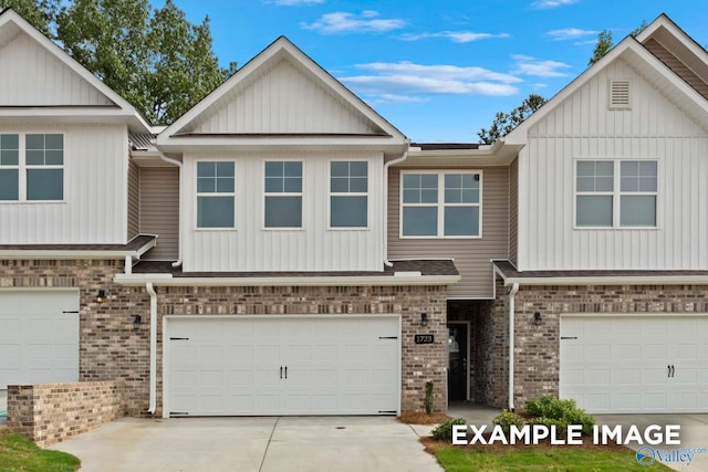 townhome / multi-family property featuring board and batten siding, brick siding, driveway, and a garage