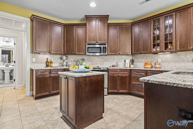 126 Mattie Ct, Madison, AL 35756 - kitchen featuring stainless steel appliances, light stone counters, light tile patterned flooring, and recessed lighting