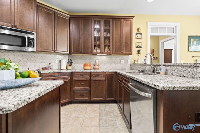 126 Mattie Ct, Madison, AL 35756 - kitchen with appliances with stainless steel finishes, tasteful backsplash, a peninsula, and light stone countertops