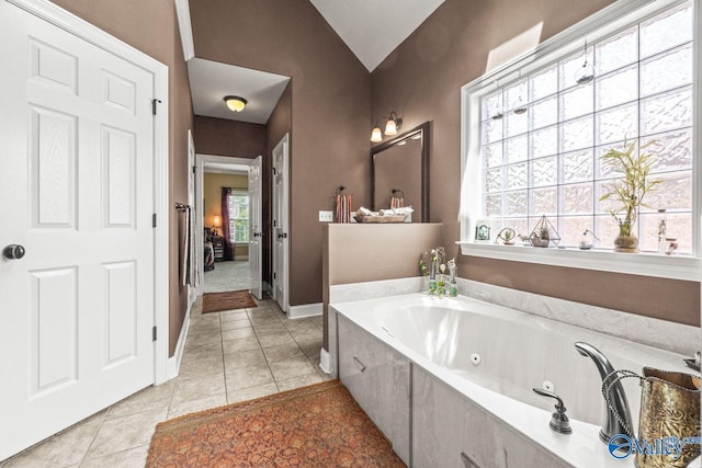 126 Mattie Ct, Madison, AL 35756 - bathroom featuring a whirlpool tub, tile patterned flooring, and vaulted ceiling