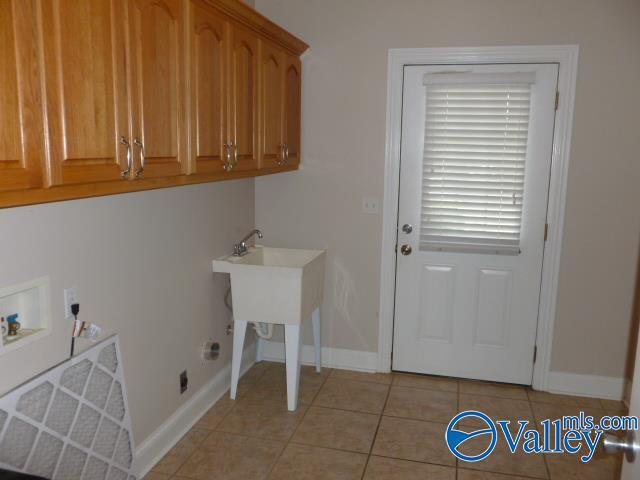 laundry area featuring hookup for a washing machine, baseboards, hookup for an electric dryer, cabinet space, and light tile patterned floors