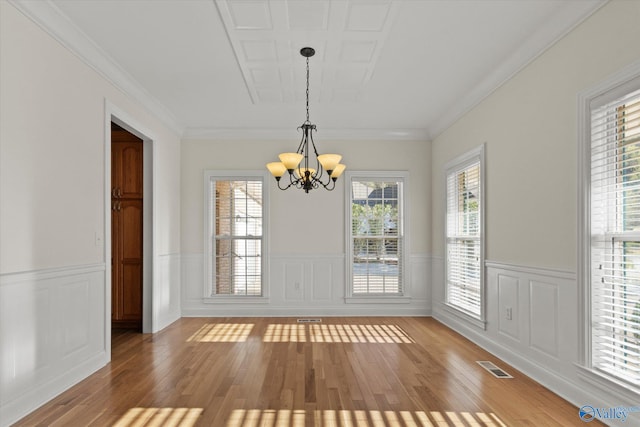 unfurnished dining area featuring visible vents, an inviting chandelier, light wood-type flooring, and wainscoting