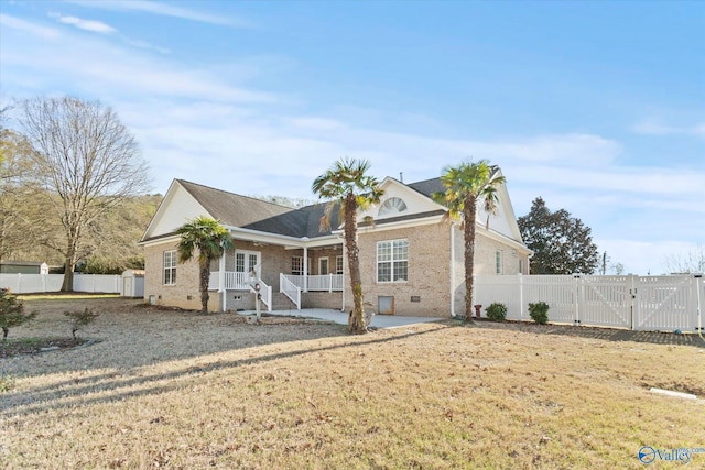 view of front of house featuring a porch, brick siding, a gate, and fence