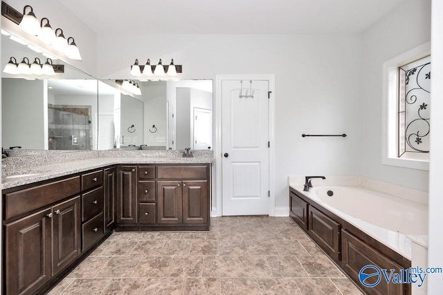 bathroom with a washtub, tile patterned flooring, and double sink vanity