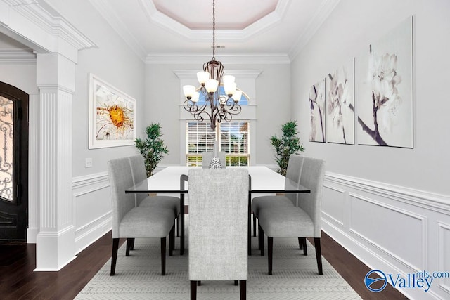 dining area featuring an inviting chandelier, crown molding, hardwood / wood-style floors, and a tray ceiling