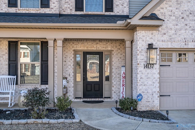 property entrance featuring a garage, brick siding, roof with shingles, and covered porch