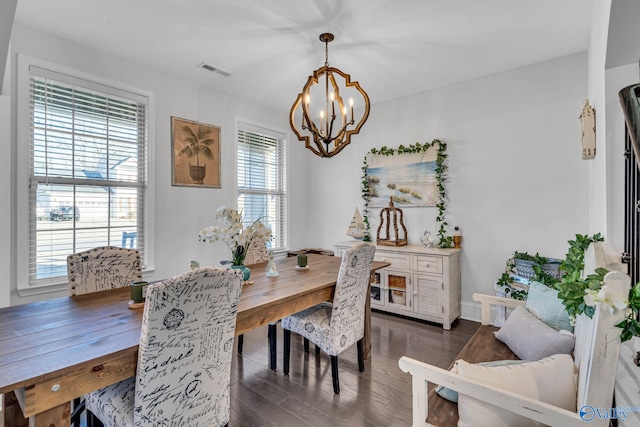 dining room with a chandelier, visible vents, and dark wood-style floors