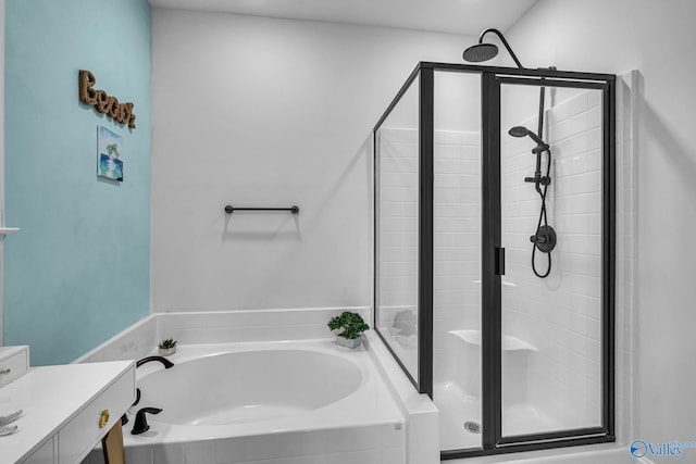 bathroom with a stall shower, a garden tub, and vanity