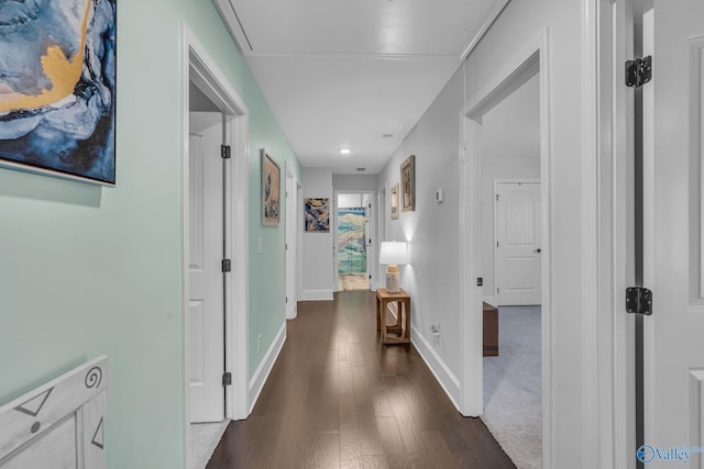 hallway with attic access, baseboards, and dark wood-style flooring