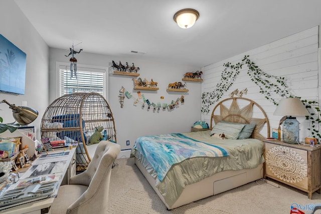 bedroom with a baseboard heating unit, visible vents, and light carpet