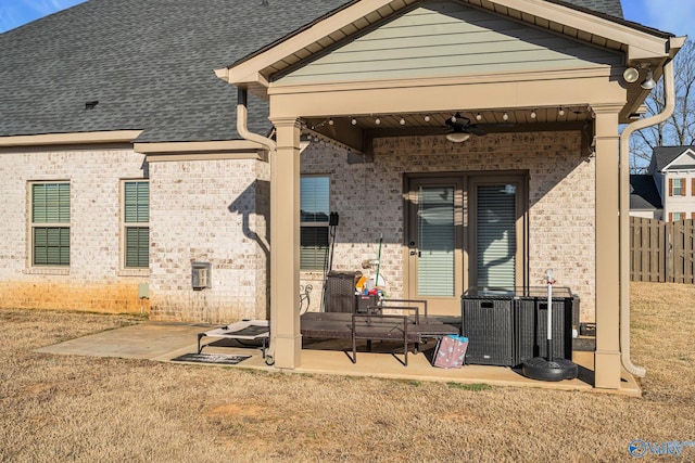 back of property featuring a shingled roof, a ceiling fan, fence, a patio area, and brick siding