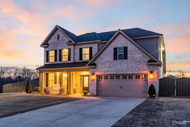 traditional-style house with a garage, covered porch, fence, and concrete driveway