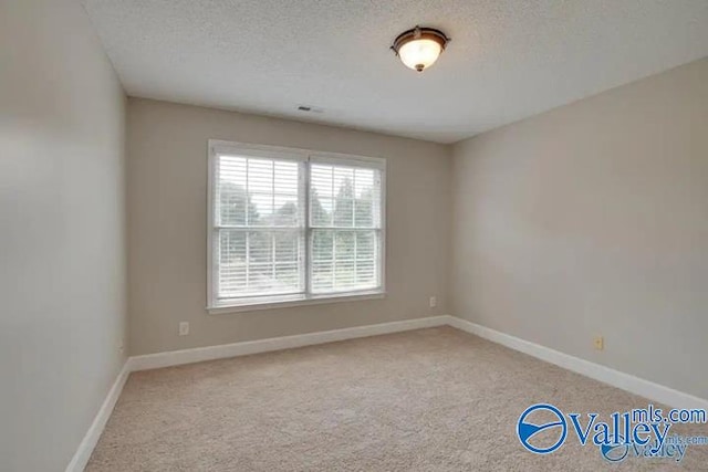 unfurnished room featuring a textured ceiling and carpet