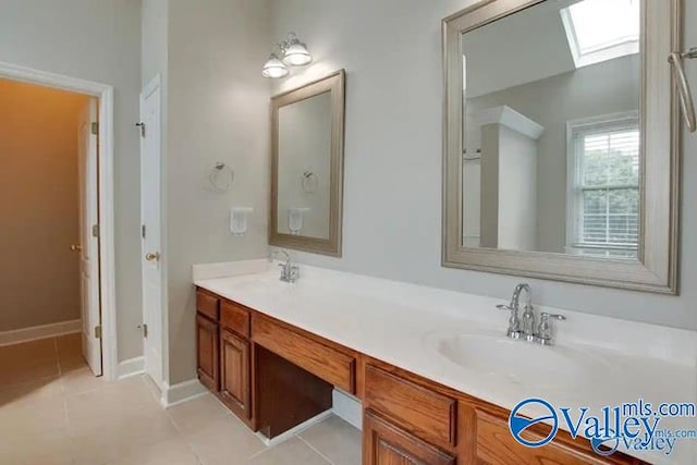 bathroom featuring tile patterned floors, vanity, and a skylight