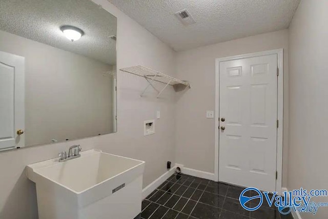 laundry area with washer hookup, a textured ceiling, and sink