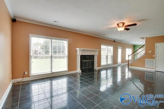 unfurnished living room featuring ceiling fan, a textured ceiling, and ornamental molding