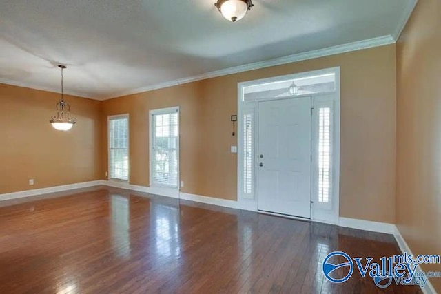 foyer entrance featuring a healthy amount of sunlight, dark wood-type flooring, and ornamental molding