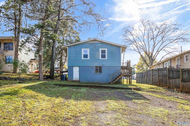 rear view of property featuring a yard and cooling unit