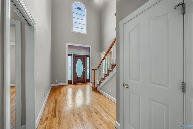 entrance foyer featuring light hardwood / wood-style flooring and a high ceiling