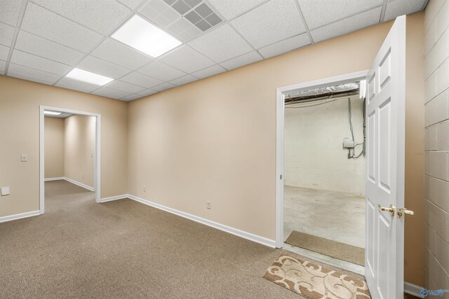 spare room featuring carpet flooring and a drop ceiling