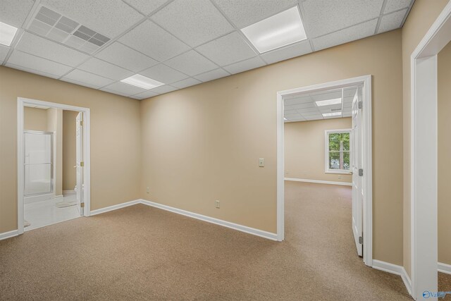 spare room with carpet and a drop ceiling