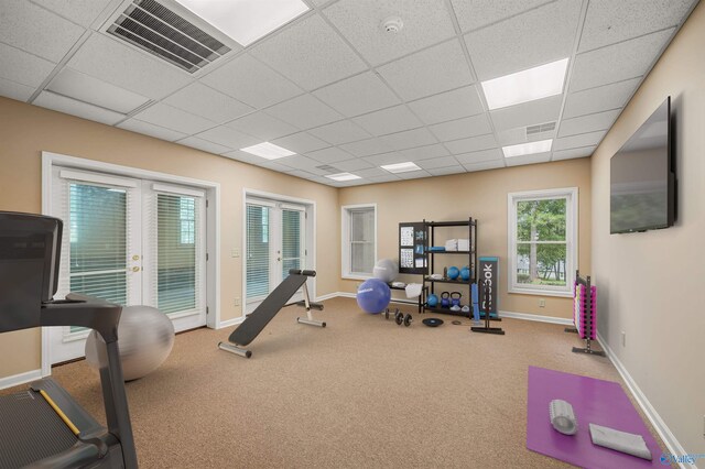 exercise room with carpet, french doors, and a drop ceiling