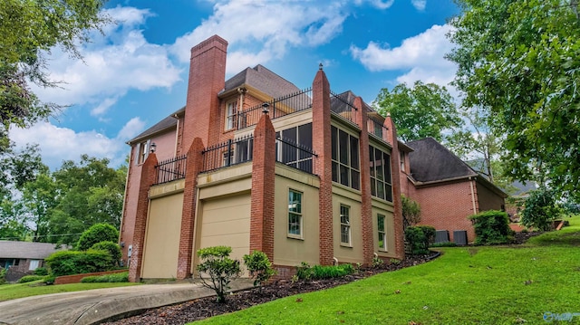 view of side of home with a balcony and a lawn