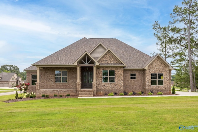 craftsman-style house with a front lawn, roof with shingles, and brick siding