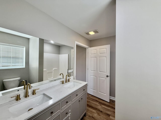 bathroom featuring vanity, toilet, hardwood / wood-style floors, and a shower