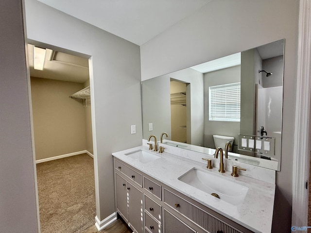 bathroom featuring vanity, toilet, and walk in shower