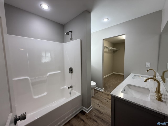 full bathroom featuring hardwood / wood-style flooring, vanity, bathtub / shower combination, and toilet