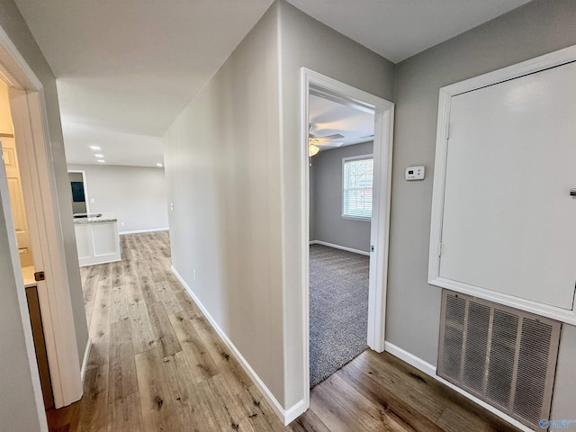 hallway with light hardwood / wood-style floors