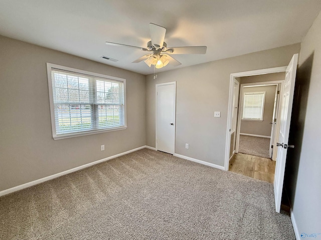 unfurnished bedroom with ceiling fan and light carpet