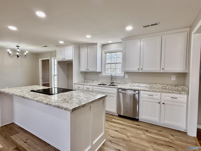 kitchen featuring stainless steel dishwasher, a center island, sink, and white cabinets