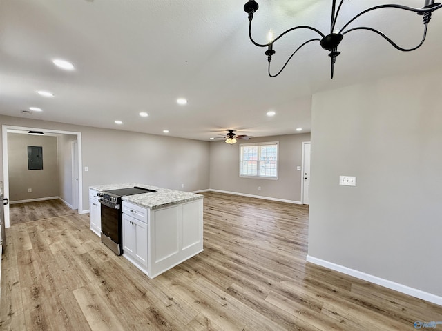 kitchen featuring range with electric cooktop, light hardwood / wood-style floors, light stone counters, and white cabinets