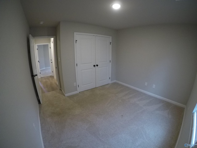 unfurnished bedroom with a closet and light carpet