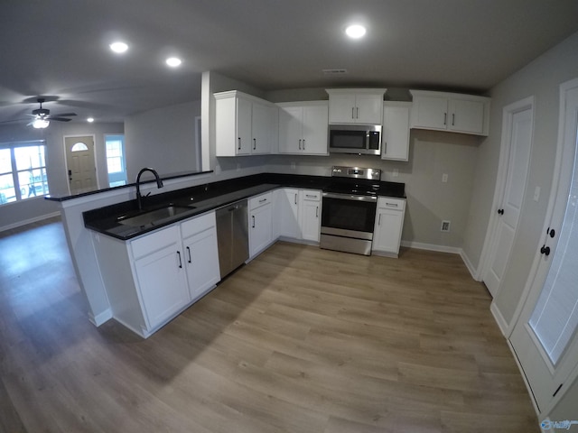 kitchen featuring stainless steel appliances, sink, white cabinets, and light hardwood / wood-style flooring