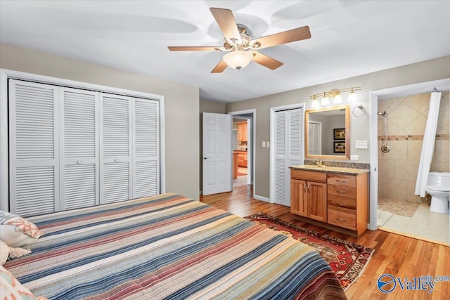 bedroom with ceiling fan, light wood-type flooring, sink, and connected bathroom