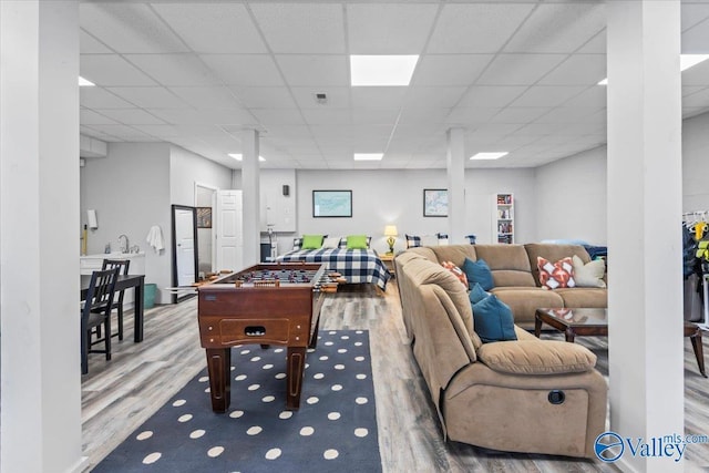 recreation room featuring hardwood / wood-style flooring and a paneled ceiling