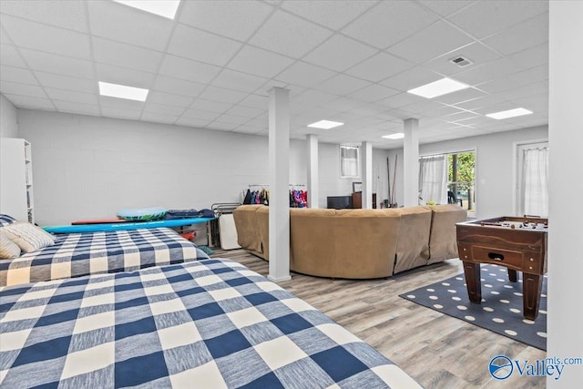 interior space featuring a paneled ceiling and light hardwood / wood-style flooring