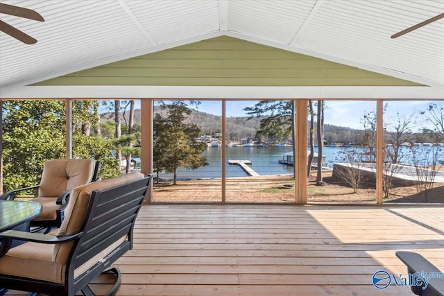 sunroom featuring ceiling fan, a water and mountain view, lofted ceiling, and a healthy amount of sunlight