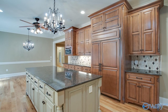 kitchen with light wood-type flooring, ornamental molding, brown cabinetry, and built in appliances