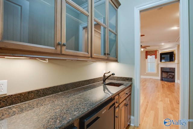 bar featuring a ceiling fan, dishwasher, light wood-style flooring, crown molding, and a sink