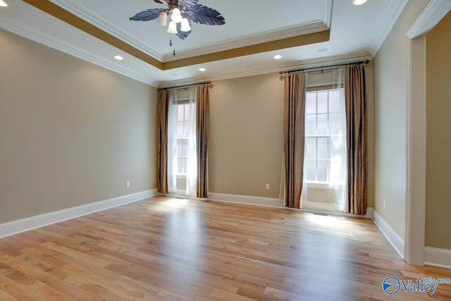 spare room featuring ceiling fan, recessed lighting, baseboards, a tray ceiling, and light wood finished floors