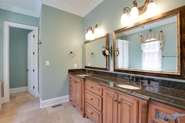 bathroom with ornamental molding, a sink, visible vents, and baseboards