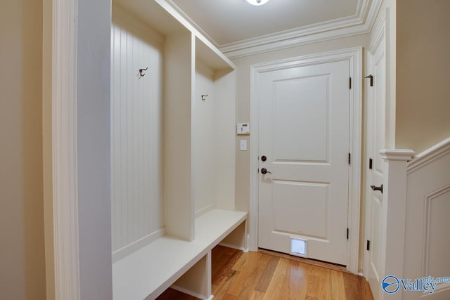 mudroom with light wood-style floors and crown molding