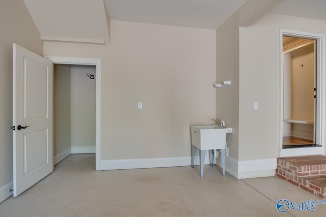 unfurnished room with concrete flooring and baseboards