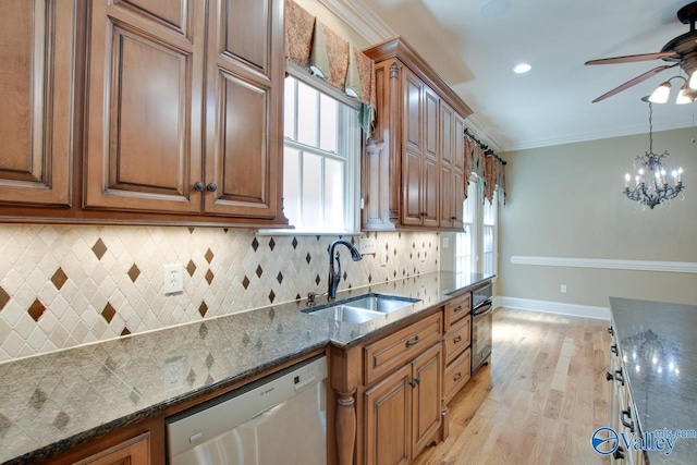 kitchen with stainless steel dishwasher, ornamental molding, brown cabinetry, a sink, and baseboards